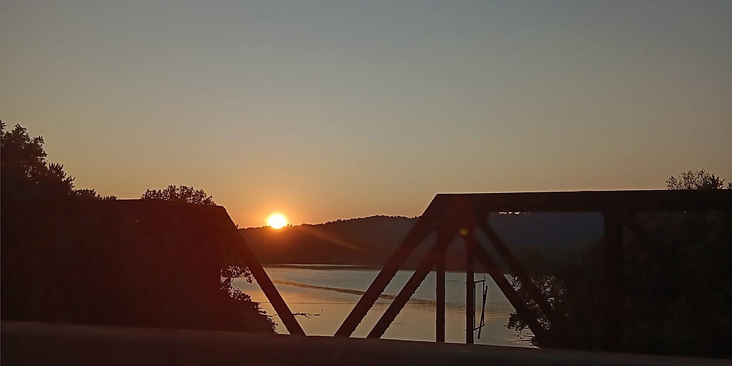 Sunrise through a river bridge